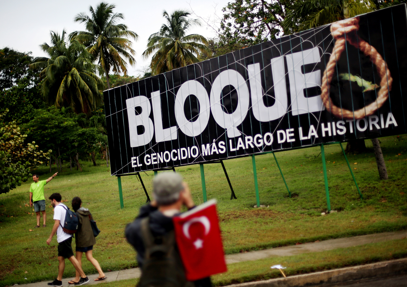 People march by a sign saying, {quote}The embargo: the longest genocide in history,{quote} during the 1st of May Labor Day March - a call for people to march in support of their local socialist government and the Cuban Revolution - in Havana, Cuba, on May 01, 2015. The commercial, financial and economic embargo enforced by the United States against Cuba went into effect in 1960, nearly two years after the deposition of the Fulgencio Batista dictatorship by the Cuban Revolution, and just after Cuba nationalized American-owned Cuban properties without remuneration to the States. The embargo at first did not apply to food and medicine, but was quickly broadened to nearly all U.S. exports. Proponents of the embargo cite repeated human rights violations in the country and the appropriated property as reasons to uphold it. Critics define the embargo as too harsh; the UN General Assembly has passed a resolution each year since 1992 criticizing its ongoing impact, citing it to be in violation of the Charter of the UN and international law. In December of 2014, U.S. President Barack Obama signaled an openness in thawing of U.S.-Cuban relations, which started with diplomatic talks and transitioned to the removal of Cuba from the U.S. list of state sponsors of terrorism in May of this year. 