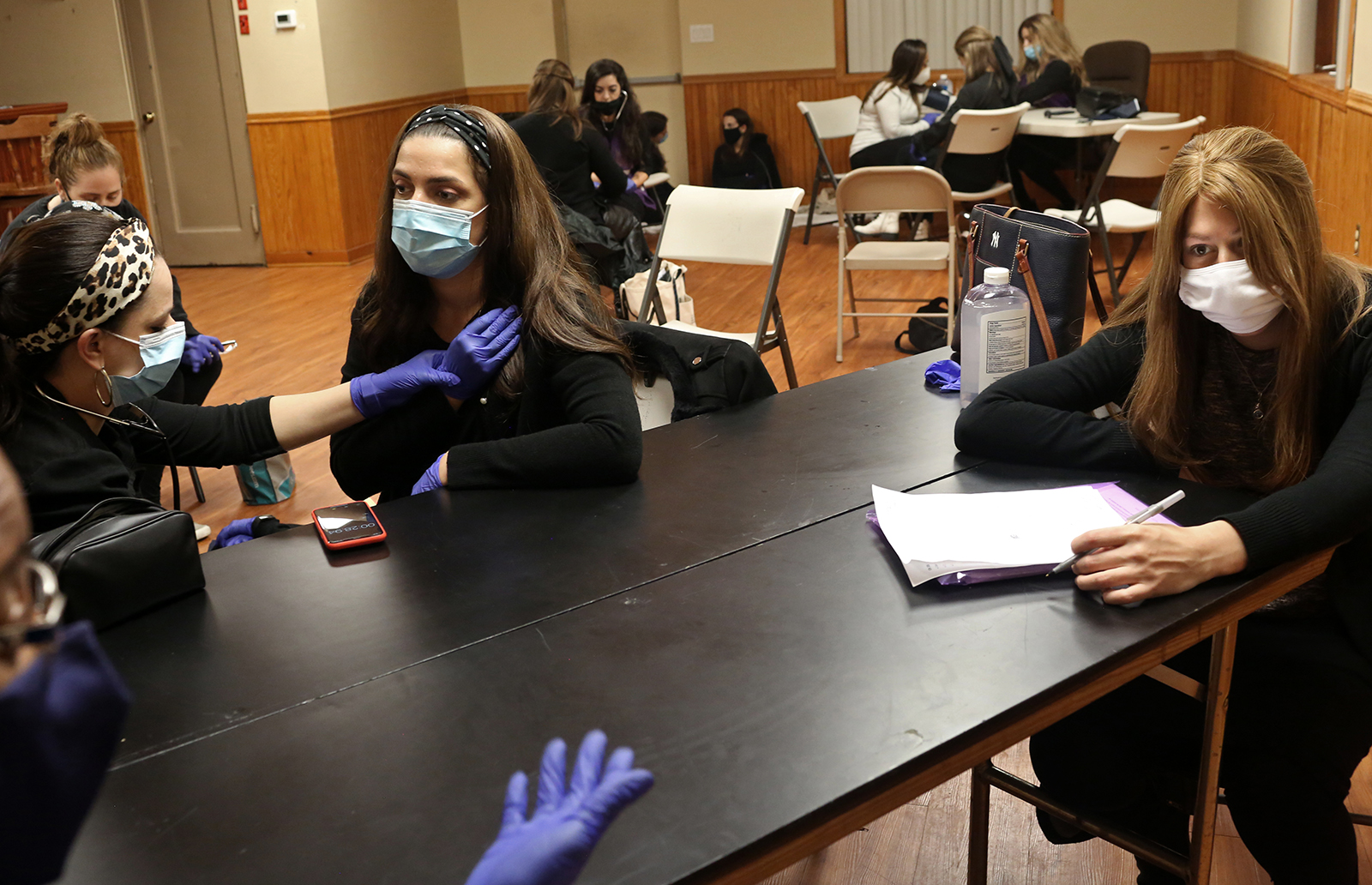 (L-R) EMT instructor Nisha Lewis, and EMT trainees Baila Eisenberger, 37, (also a hair stylist,) Leah Goldberger, 26, (also a pharmacy student,) and Elizabeth Freud, 26, (also a teacher,) take part in an EMT skills training in New York on November 05, 2020. (Photo by: Yana Paskova for The New York Times/the National Geographic Society)