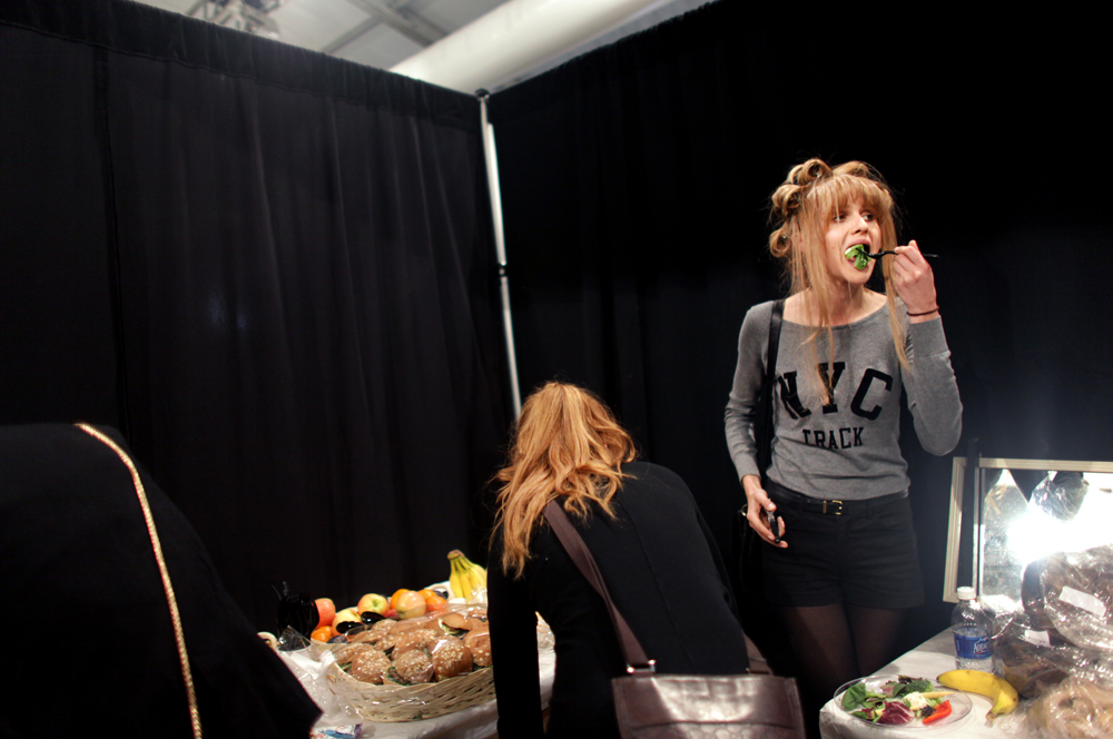 A model has a bite to eat before a fashion show, September 12, 2012, at Mercedes-Benz Fashion Week in New York, NY. (For The New York Times)