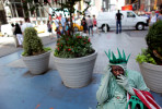 Amadou Tandia takes a smoking break from posing for tourist photos dressed as the Statue of Liberty in Times Square in Manhattan, New York on Monday, August 13, 2012.(For The New York Times)