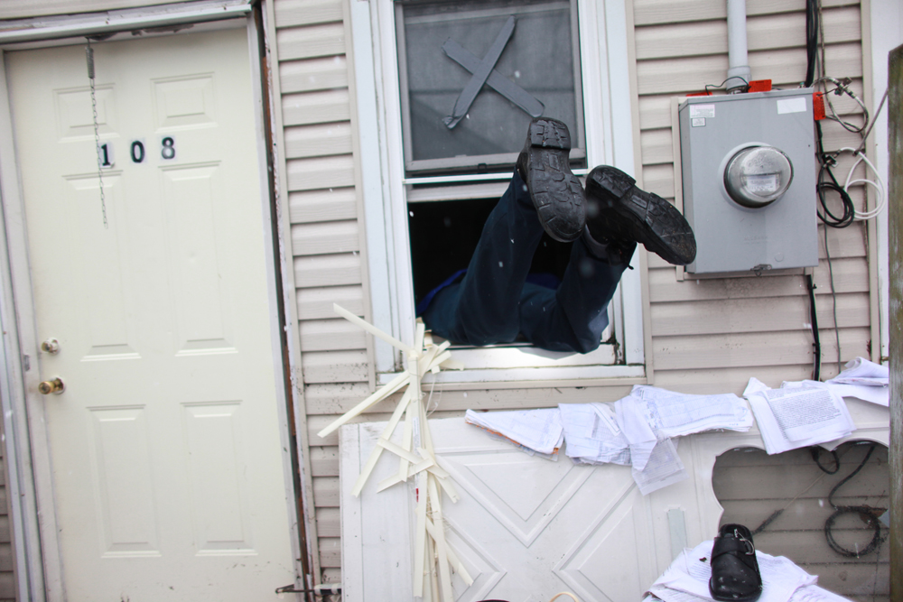 Thomas Carr enters his home through the window to unlock the front door during a Humane Society rescue call of his cat, Bunny, and dog, King, in Island Park in Long Island, New York, on Wednesday, November 07, 2012. Many residents evacuated in a hurry without the means to take their pets, nor without realizing it may be days before they could return to rescue them. (For The Humane Society)