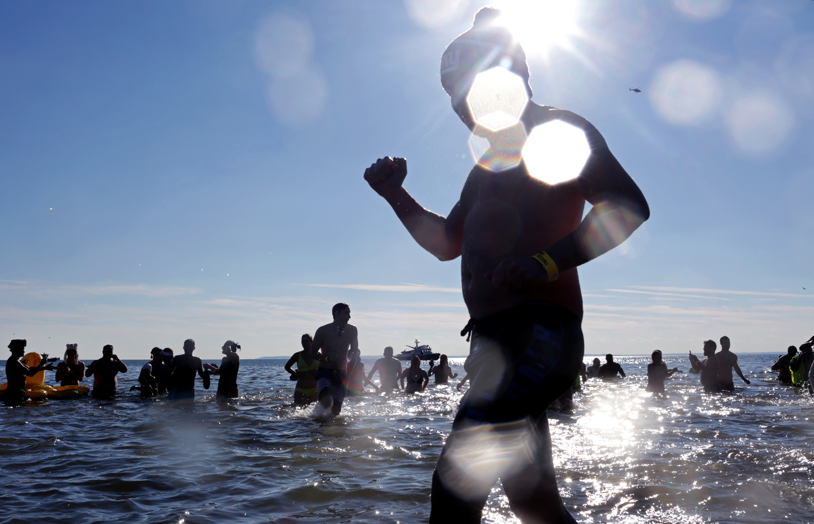 Swimmers run into the ocean during Coney Island Polar Bear Club's New Year's Day Plunge on January 01, 2017 in Brooklyn, NY.