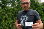 Scott Lobaido poses with the card he says he shows when anyone asks his for his coronavirus vaccination card, during an anti-coronavirus-vaccination-mandate protest in front of the Staten Island University Hospital (Northwell Health) on Staten Island, NY on August 16, 2021. Earlier in the day, outgoing New York Governor Andrew Cuomo issued a directive that all healthcare workers in the state must have at least one dose of the coronavirus vaccination done by September 27, 2021. 