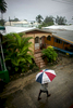 A man shields himself from the rain in Holetown in Barbados on Saturday, April 10, 2010. (For The New York Times)