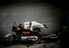 A man sleeps on his bike in New Delhi, India, in May 2009.