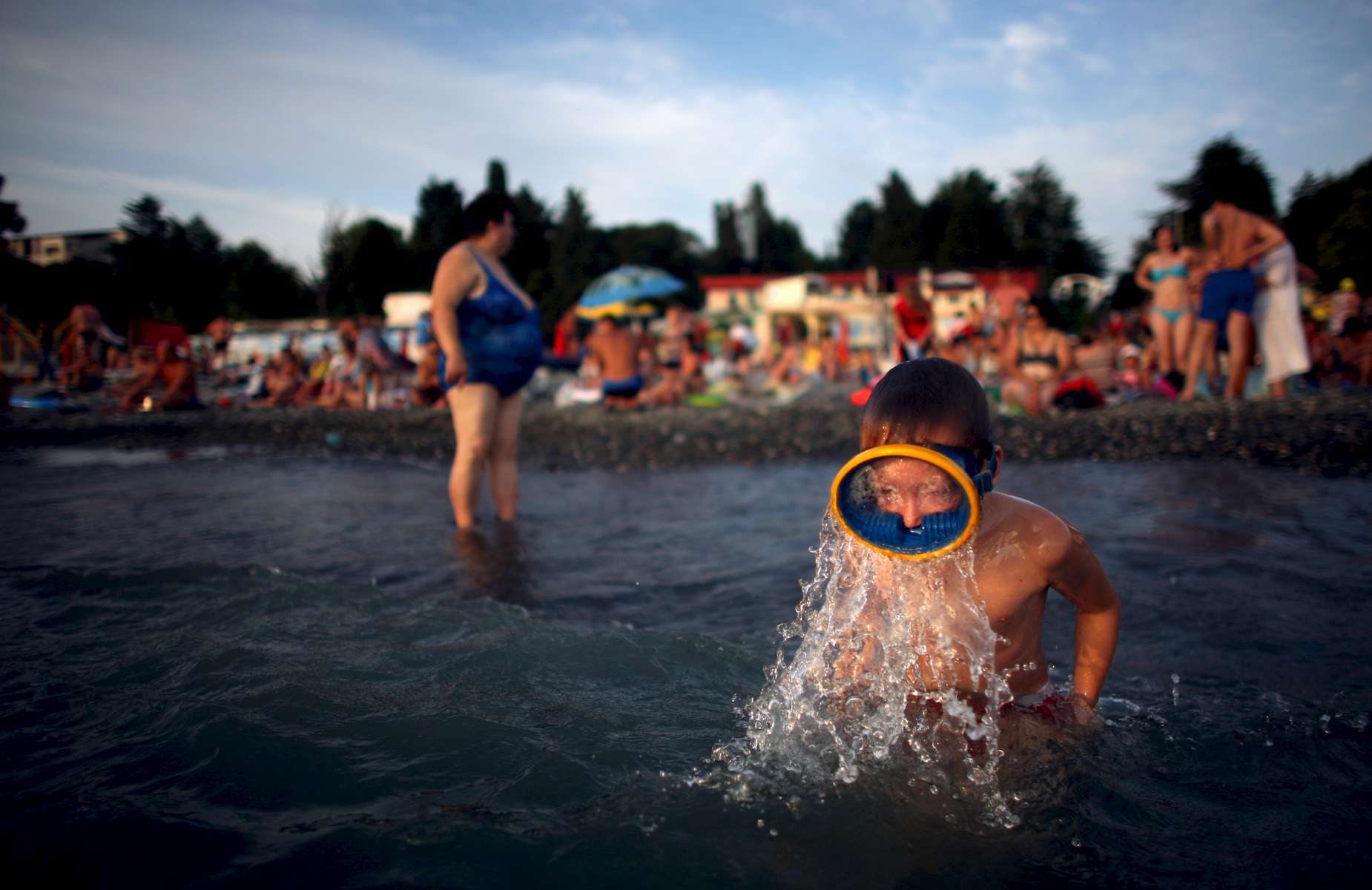 A boy emerges from the water in his scuba diving mask as beach-goers enjoy the warm weather on Thursday, August 14, 2008, at the Black Sea resort Sochi, Russia. The government has pledged to invest $12 billion to transform the Soviet-era resort town into a Mediterranean-style retreat.   As the mountainous Black Sea resort Sochi, Russia, prepares for the Winter Olympic games scheduled there for 2014, it emerges as a place replete with contradictions -- glitzy clubs and impoverished street vendors, progress and repression, Westernization and former Eastern bloc ideologies. 