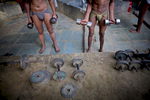 Indian men practice traditional Kushti wrestling on Monday, June 01, 2009 in New Delhi, India. Kushti, India's indigenous form of wrestling, has gone from a royal national sport to a dying art in Asia over the past century.  Those who still practice it meet the lengthy hours of its daily regimen with unrelenting devotion — rope, aerobic and weight exercises; culturing the soil on which they wrestle; a diet comprised of non-spicy, self-made food; and celibacy.  And so, in traditional earthen pits wrestlers still apply the physical and mental intensity that has driven their ancestors for three thousand years.  But a 2004 decision by the Indian Fighters Federation from the capital of Delhi, prohibiting fighting on red soil and ordering fight clubs to use mattresses instead, exacerbated Kushti's diminishing role in Indian tradition.  The order was in part an effort to gather more Olympic medals -- the first by Khashaba Dadasaheb Jadhav, a bronze in 1952, and most recently, also a bronze at the 2008 Beijing Olympics, by Sushil Kumar. 