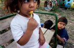 A little girl sucks a lollipop under the hungry gaze of a little friend at the Dom Maika i Dete (Home for Mother and Child) adoption home in Vidin, Bulgaria on August 31, 2008.Children for adoption in Vidin, Bulgaria, live here. The home's director, Maria Rangelova, describes that two decades ago, the home carried more than double the children, who were mostly given away because they were born out of wedlock. While the number of children has decreasted from about 180 to 80 from waning birth rates and shifting cultural perceptions of birth outside of marriage, there remain many kids in need of adoption. Now, she says, most parents who give their children away do so because of financial want -- one that robs them of the ability to support their kids, or leaves them unable to cure an illness that has incapacitated them as caregivers. The home often struggles to provide an adequate amount of toys, snacks and personnel necessary for the children's caregiving. 