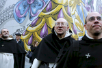 (L-R) Fr. Ambroise Pellaumail, Fr. Louis De Blignieres, and Fr. Reginald Rivoire, from Fraternite Saint Vincent Ferrier in France, walk by Trump Tower, the current residence of Republican President elect Donald Trump, in Manhattan, NY on November 18, 2016.-{quote}Trump Gawkers{quote} is a visceral look at what draws people to Trump Tower, through in-depth interviews and still photos - a project I started the day after the election. At first, I simply followed where my assignments sent me, but then found myself returning to the place on my own, unable to look away - and I wasn’t alone. Hoards of people undertake the trek, bearing security and weather roadblocks, to stare, gawk, absorb, record. The magnetism to Trump Tower (and by extension, to the man in the tower,) manifests in the sheer numbers of daily visitors, as well as in the fascination etched across their faces. Upon first look, the time so many spend there seems like sport and amusement, but underneath upturned eyes and selfie smiles prevails an undercurrent of anxiety - and not just for those who didn't want Trump in the Oval Office. Some of the electorate that voted against Hillary is now unsure for which version of Trump they voted. People's upward gazes, no matter their political views, seek answers: How could this happen? Or now that it has, what will it mean? 