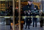 David Skellington,  doorman of Trump Tower of eight years, the current residence of Republican President elect Donald Trump, looks out onto passersby photographing the building in New York, NY on December 15, 2016. On crowds constantly recording Trump Tower, Skellington said: {quote}It's interesting, you see a lot of people, it's history. But this could be awkward, so many people taking pictures. I'd rather be behind the camera. My family and friends are always seeing me on the news. Tourists say, 'you're famous.' {quote} -{quote}Trump Gawkers{quote} is a visceral look at what draws people to Trump Tower, through in-depth interviews and still photos - a project I started the day after the election. At first, I simply followed where my assignments sent me, but then found myself returning to the place on my own, unable to look away - and I wasn’t alone. Hoards of people undertake the trek, bearing security and weather roadblocks, to stare, gawk, absorb, record. The magnetism to Trump Tower (and by extension, to the man in the tower,) manifests in the sheer numbers of daily visitors, as well as in the fascination etched across their faces. Upon first look, the time so many spend there seems like sport and amusement, but underneath upturned eyes and selfie smiles prevails an undercurrent of anxiety - and not just for those who didn't want Trump in the Oval Office. Some of the electorate that voted against Hillary is now unsure for which version of Trump they voted. People's upward gazes, no matter their political views, seek answers: How could this happen? Or now that it has, what will it mean? 