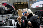 Debra Tomarin takes selfie in front of Trump Tower, the current residence of Republican President elect Donald Trump, in New York, NY on December 08, 2016. Tomarin is a real estate agent and retired psychotherapist - and lives in Palm Beach, FL, down the street from Trump's Florida residence, Mar-a-Lago. On people protesting Trump's nomination of Oklahoma Attorney General Scott Pruitt as the head of the Environmental Protection Agency - a man who has sued the EPA more than a dozen times to block air, water and climate protections - outside of Trump Tower, she said: {quote}Protesting is irrelevant and wrong, and won't make a difference. He won't even see it, and people don't stop to pay attention. We have to move on. It's too late to sell anti-Donald Trump buttons. They should be asked to leave. Sure, they have a right to be out here, but what about his right to live in a home without someone standing in front of it with a sign?{quote}On climate change, she said, {quote}I believe climate change is real. I am not concerned about this because of his choices of cabinet people and because his children understand climate change is real. But maybe he hasn't been paying attention so far, being so busy with his business, and now he has to.{quote}On Pruitt as the choice to lead the EPA, she said: {quote}Pruitt as the head of the EPA is an interesting appointee. I think that's making a statement that he'll turn this guy around. This guy, Pruitt, is aware of climate change despite being against it. Trump did this because he's gotta please the people. Trump has a strategy - he takes the underdog and turns him around because he likes a challenge. Sometimes people do the opposite of what they want to do, because they like a challenge. There's a method to his madness. You don't want a guy you can just push over, and he wants a challenge in this guy. This is his strategy - who's going to pay attention to a guy who is simply for battling climate change as opposed to a guy who's against it, yet actually ends up battling it? Now that's a wake-up call.{quote}-{quote}Trump Gawkers{quote} is a visceral look at what draws people to Trump Tower, through in-depth interviews and still photos - a project I started the day after the election. At first, I simply followed where my assignments sent me, but then found myself returning to the place on my own, unable to look away - and I wasn’t alone. Hoards of people undertake the trek, bearing security and weather roadblocks, to stare, gawk, absorb, record. The magnetism to Trump Tower (and by extension, to the man in the tower,) manifests in the sheer numbers of daily visitors, as well as in the fascination etched across their faces. Upon first look, the time so many spend there seems like sport and amusement, but underneath upturned eyes and selfie smiles prevails an undercurrent of anxiety - and not just for those who didn't want Trump in the Oval Office. Some of the electorate that voted against Hillary is now unsure for which version of Trump they voted. People's upward gazes, no matter their political views, seek answers: How could this happen? Or now that it has, what will it mean? 