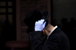 A man adjusts his hat as he waits in line to get tested for coronavirus antibodies at the Refuah Health Center on April 24, 2020 in Spring Valley, NY. (Photo by Yana Paskova/Getty Images)
