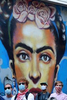 A mural of Marxist feminist painter Frida Kahlo peers over a Black Lives Matter protest, under the Broadway MTA tracks in Brooklyn, NY on June 12, 2020. 