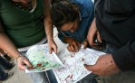 Local community members from Valencia Creek look over a fire map detailing the proximity of the Great Divide South fire to the town. Locals were on hand for a community meeting staffed by DSE and CFA personnel to explain the severity of the fire threat.