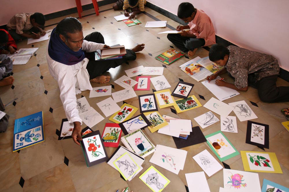 John Kennedy Samson lays out the children’s drawings that he tries to sell as a way to raise money for the orphanage since it lacks any government sponsorship. {quote}Paying for the education is the toughest. I am disappointed in life sometimes when I give everything and still it is not enough.{quote}