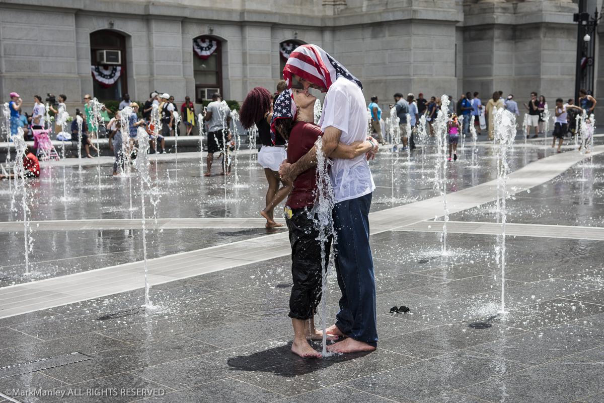 Tom Haws from Mesa Arizona and Pam Borden from Raleigh North Carolina share an embrace while cooling off in a fountain at City Hall in Philadelphia during the DNC. The previous day both were arrested along with approximately thirty other members of the group Democracey Spring while conducting non-violent civil disobedience, climbing over barriers outside the convention's restricted event zone and into the hands of waiting police.