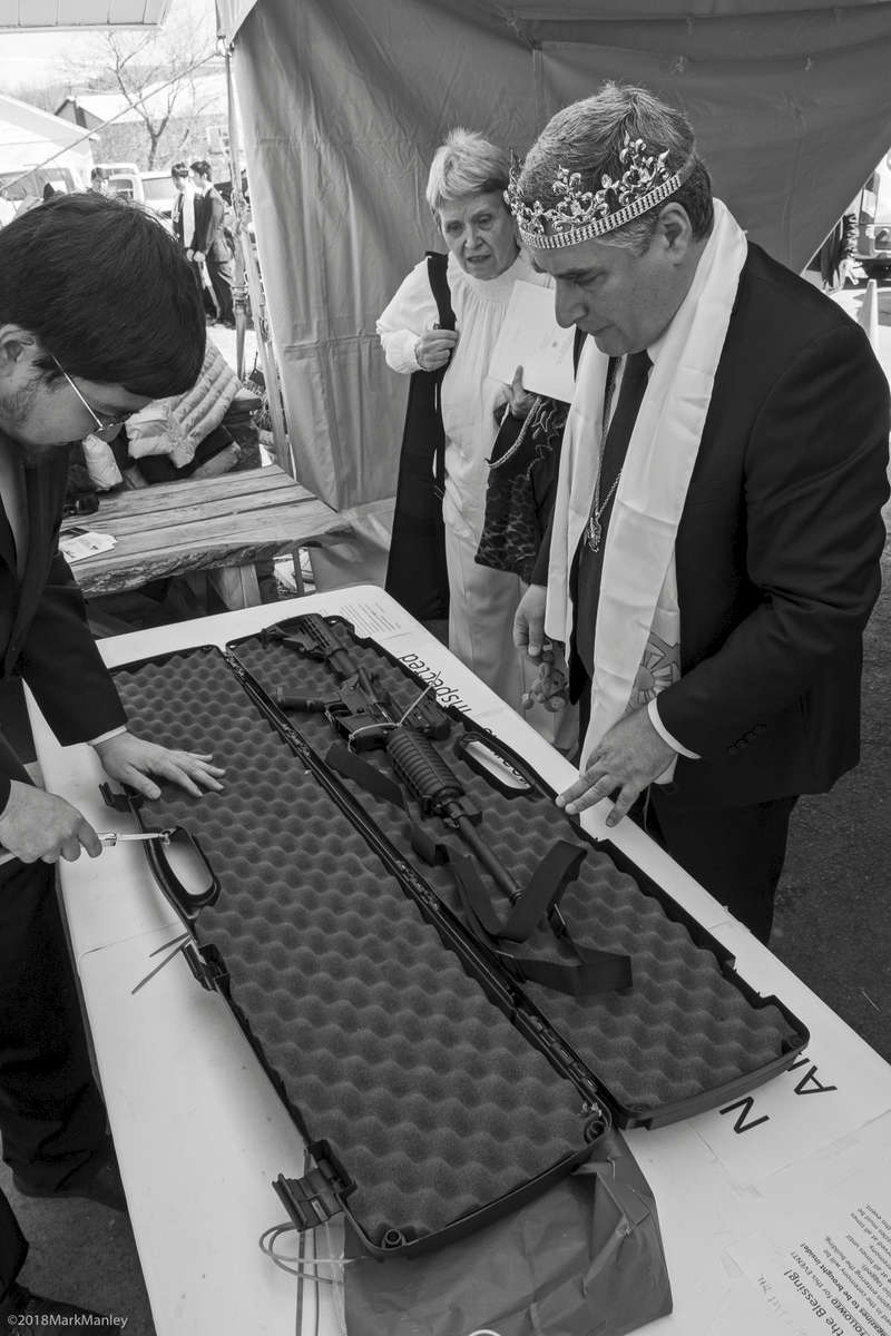An attendee's weapon is inspected and the zip-tie removed following the ceremony.