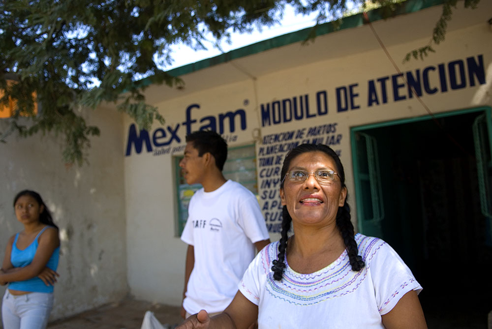 Bersain and his mother outside the Mexfam clinic in Tyustauo Pineda. A young girl looks on. Bersain and his mother continue to operate the clinic in this rural area.