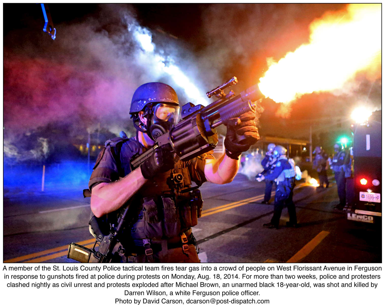 A member of the St. Louis County Police tactical team fires tear gas into a crowd of people on West Florissant Avenue in Ferguson in response to gunshots fired at police during protests on Monday, Aug. 18, 2014. For more than two weeks, police and protesters clashed nightly as civil unrest and protests exploded after Michael Brown, an unarmed black 18-year-old, was shot and killed by Darren Wilson, a white Ferguson police officer.Photo by David Carson, dcarson@post-dispatch.com