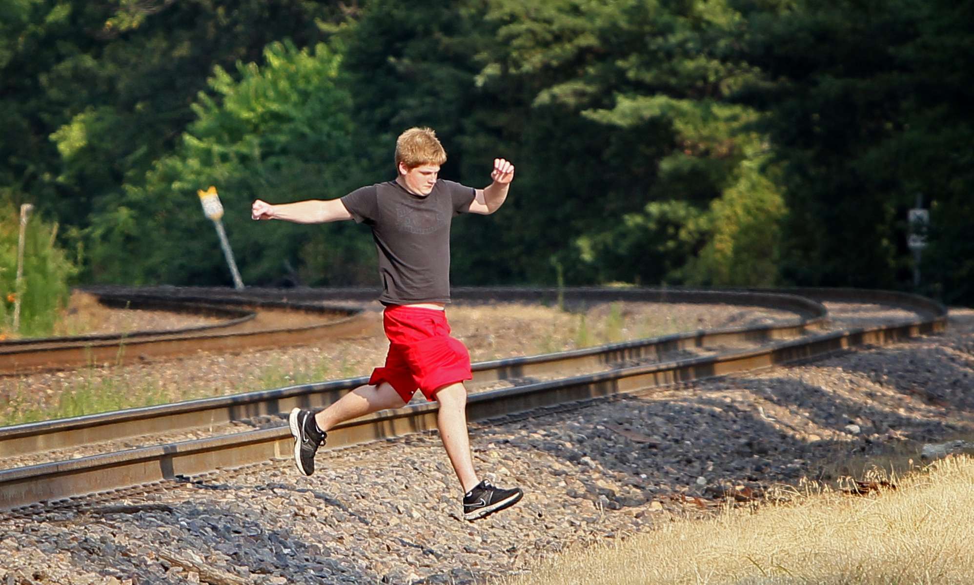 Austin Huster, 16, crosses the train tracks near where Cam Vennard, 14, was killed by a train on his way to a memorial concert, Cam Jam, in Cam's honor on July 12, 2012 in Kirkwood.  Cam, 14, was walking along the tracks east of downtown Kirkwood when he was struck and killed by westbound train in May of 2012.  After crossing the tracks Huster and a friend stopped by a make shift memorial for Cam and then continued walking to the concert.Photo By David Carson, dcarson@post-dispatch.com
