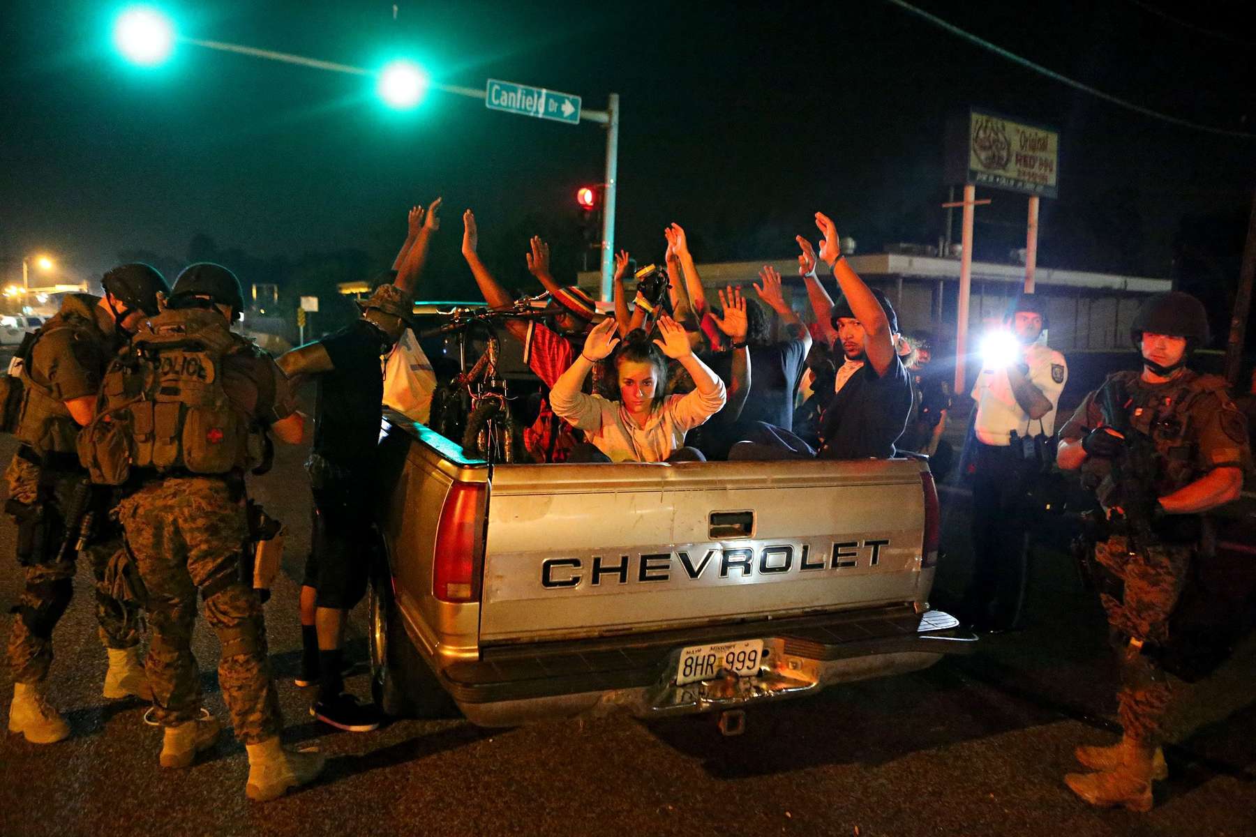 Members of the St. Louis County Police tactical team take a truck load of 12 people into custody after they stopped it driving along W. Florissant Road near Canfield Drive in Ferguson, Mo. on Tuesday, Aug. 19, 2014.  The police found two loaded guns on the people in the truck and removed a large Molotov cocktail from the truck.