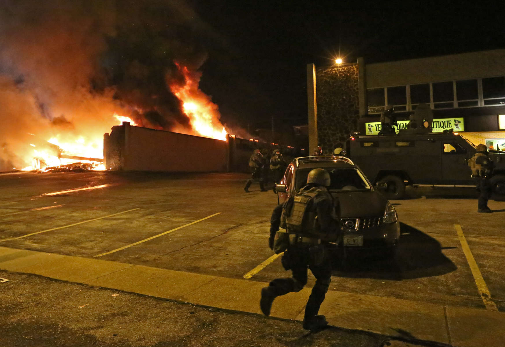 Police officers gather outside the Beauty Town building as it is engulfed in flames on Monday, Nov. 24, 2014. Photo By David Carson, dcarson@post-dispatch.com