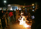 A protester lights a flag on fire outside the Ferguson police department on Saturday, Nov. 29, 2014.  The protester needed to add an accelerant to the flag to get it to burn when they he was unable to get it to ignite with just a lighter.Photo By David Carson, dcarson@post-dispatch.com
