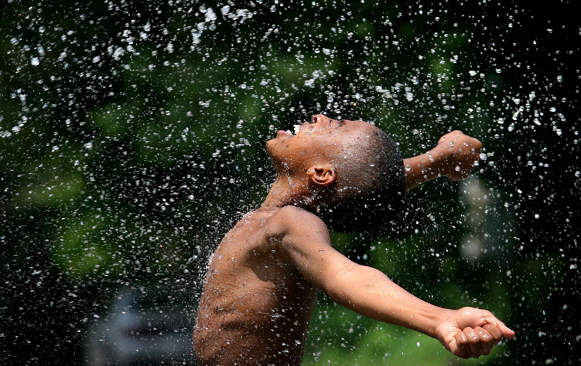 Thursday June 25, 2009--Gerrell Lawson, 12, basks in the spray of a garden hose as he plays with is friends is Hillsdale on Thursday.  Thursday marked the eighth straight day of temperatures above 90 and Saturday is expect to top out close to 100 with some cooling into the upper 80s expected for Sunday.David Carson    dcarson@post-dispatch.com