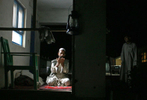 Afghanistan Five Years Later-Power--A guard performs his prayers bathed in the glow of an electric light in  Dasht-e Qal'eh, a small town in northestern Afghanistan.  While the town only receives three hours of power a night, five years ago there was none.