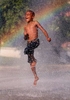 Antonie Baker, 8, leaps through the spray of a cooling station that was set up in front of the Gamble Community Center in St. Louis. An excessive heat warning was issued by the National Weather Service for the St. Louis area.
