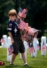 Cub Scout Nick Kollar, 8, from Eureka, places flags in front of head stones at Jefferson Barracks National Cemetery. Kollar was one of more than 5,000 local scouts who showed up to help place flags at the more than 139,000 head stones at the cemetery. This was the 61st annual Memorial Day {quote}Good Turn{quote} event that was sponsored by the Gravois Trail District of the Greater St. Louis Area Council, Boy Scouts of America.  