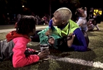 Tiffany Spain, 29, covers her daughter Logynn Spain, 4, as she calls out to her other child to run to her for cover as gun shots ring out from a car driving by Sumner High School during a football game between Vashon High School and Gateway STEM High School on Friday, Oct. 2, 2015. The shots were so close that people could smell smoke from the gunpowder. The gunfire scattered fans game but no one at the game was hurt by gun fire. {quote}They're my kids...I'd rather for me to get hit than them{quote} said Spain. After a short interruption, the game started up again. Photo by David Carson, dcaroson@post-dispatch.com