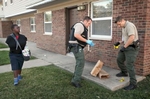 Fourth grader James McClain, 9, watches as Illinois State Police troopers Grant Hentze (center) and James Randolph gather evidence from a long blood trail that stretched through the Ernest Smith housing complex in Centreville after three people were shot early Friday, Sept. 13, 2013.  McClain has his arms tucked in his shirt to keep warm in the chill of the morning air.Photo By David Carson, dcarson@post-dispatch.com