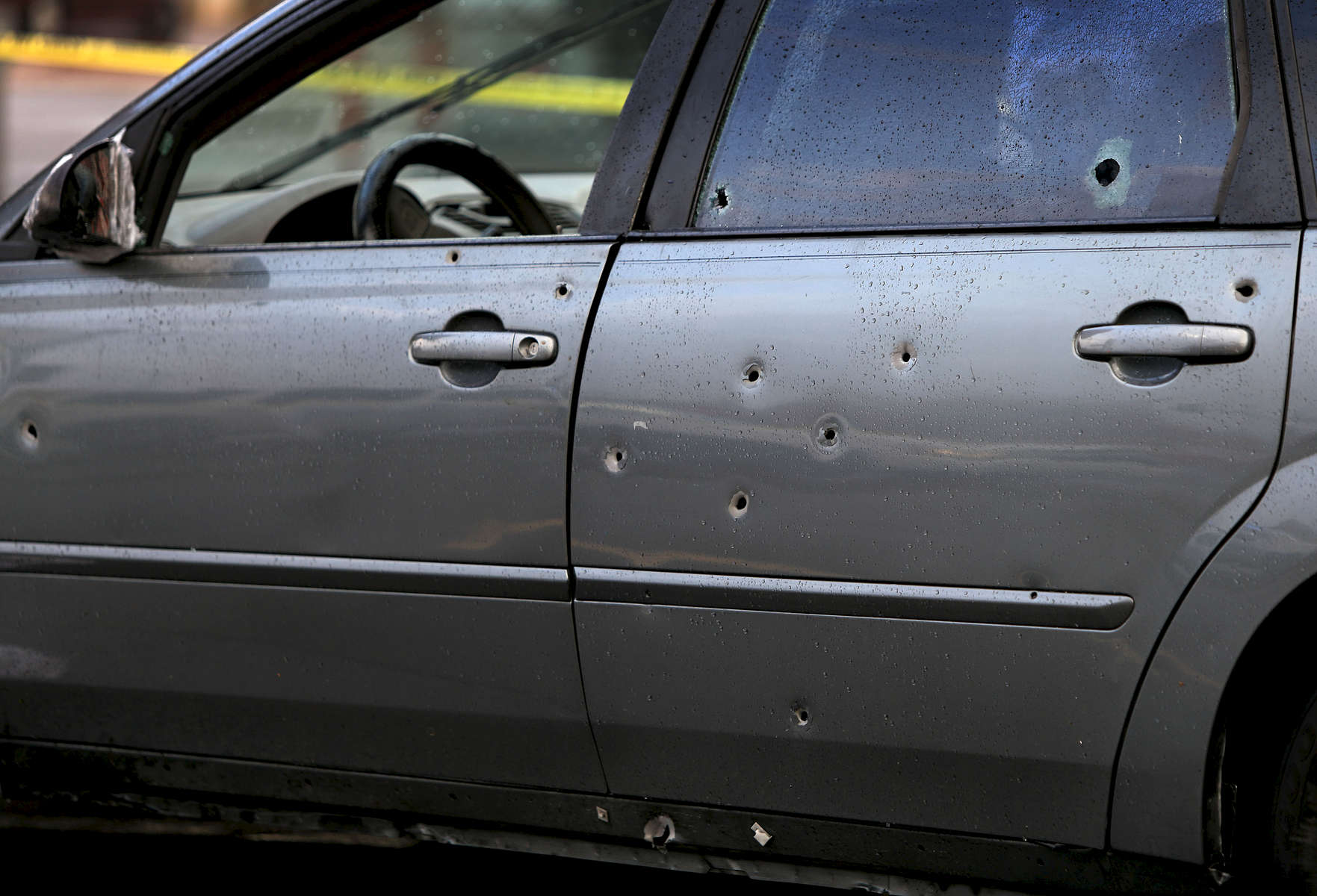 At least 14 bullet hole are visible on the driver's side of the car in a gas station parking lot at Natural Bridge Avenue and Union Boulevard where a man who was shot in the back drove to on Sunday, Nov. 5, 2017.  Police say the shooting occurred near Palm Street and Geraldine Avenue around 3 p.m. The man was conscious and breathing when he was taken to the hospital by ambulance. Another passenger in the car was unhurt by the gunfire. Photo by David Carson, dcarson@post-dispatch.com