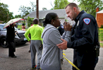 Vanita Walker (left) talks with North County Police Cooperative officer Albert Haller as police investigate the scene of a triple homicide on 4500 block of Rosewood Avenue in Pine Lawn on Wednesday, April 26, 2017. {quote}That's my son's car,{quote} said Walker as she pleaded to be let into the crime scene so she could identify her son. Walker tried to calm her and explain to her why she couldn't enter the scene as it was be investigated. {quote}As a human you just feel for her,{quote} said Haller a little later after Walker moved back from the police line.Photo by David Carson, dcarson@post-dispatch.com