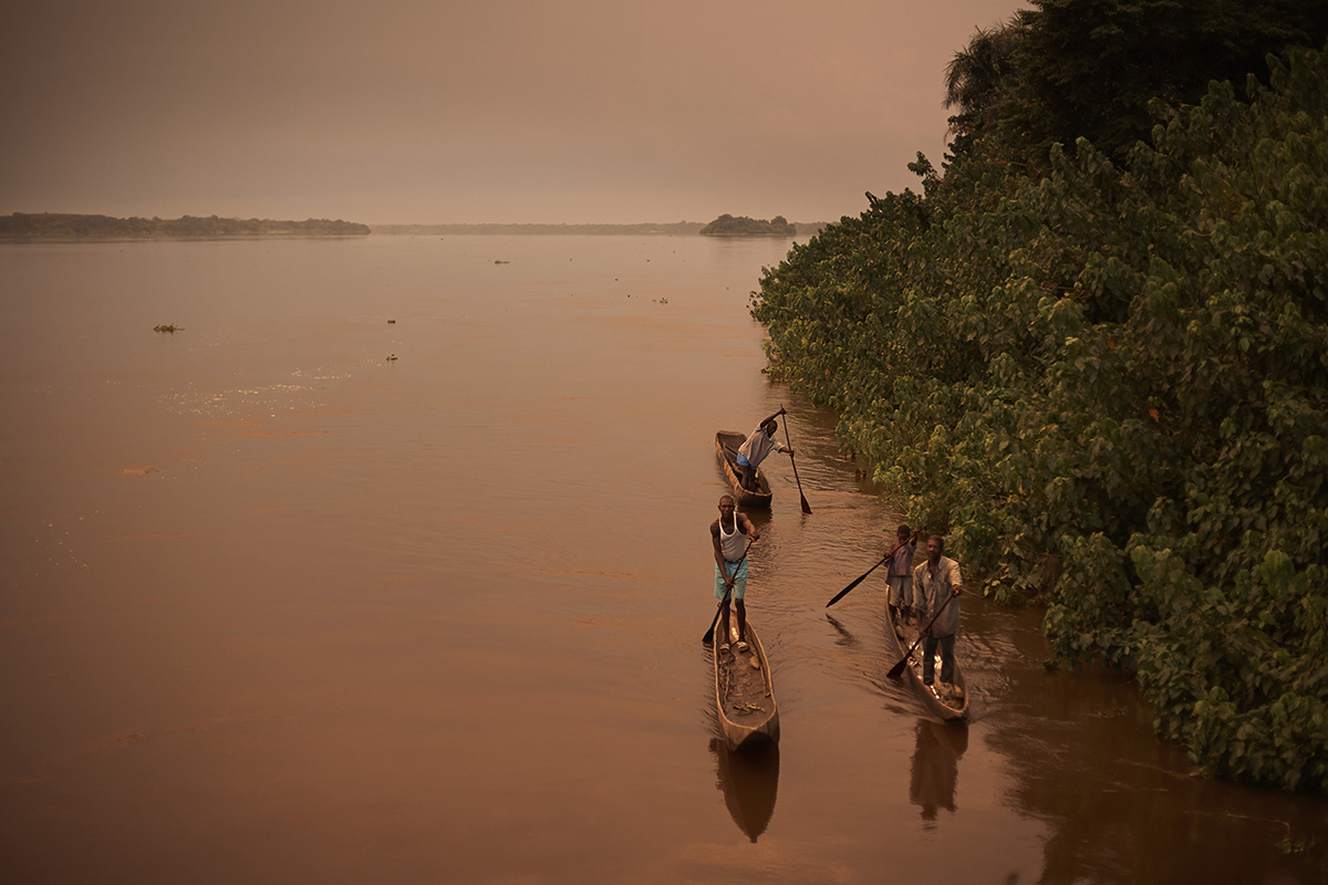 BUMBA, DEMOCRATIC REPUBLIC OF CONGO APRIL 6: Unidentified villagers paddle in their wooden dugout canoes along the Congo River on April 6, 2006 in Bumba, Congo, DRC. The river is a lifeline for millions of people, who depend on it for transport and trade. Many boats are traveling on the river with goods and passengers. The longest schedule route is between Kisangani and Kinshasa, the Capital, a journey of 1750 kilometers. Congo, DRC is planning to hold general elections by July 2006, the first democratic elections in forty years. (Photo by Per-Anders Pettersson)