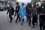 KINSHASA, DEMOCRATIC REPUBLIC OF CONGO - FEBRUARY 10: Papa Griffe (in blue suit), a senior and a leader of the Sapeurs walks with some of his men after paying his respect to Stervos Nyarcos, the founder of the .kitendi religion., which means clothing in local language Lingala. Nyarcos was known as the leader of the Sape movement, at Gombe cemetery on February 10, 2012 in Kinshasa, DRC. The word Sapeur comes from SAPE, a French acronym for SociÈtÈ des Ambianceurs et Persons …lÈgants. or .Society of Revellers and Elegant People. and it also means, .to dress with elegance and style{quote}. Griffe has been a sapeur most of his life, and owns a few business and a car. He was made a career of being a sapeur. Most of the young Sapeurs are unemployed, poor and live in harsh conditions in Kinshasa,  a city of about 10 million people. For many of them being a Sapeur means they can escape their daily struggles and dress like fashionable Europeans. Many hustle to build up their expensive collections. Most Sapeurs could never afford to visit Paris, and usually relatives send or bring clothes back to Kinshasa. (Photo by Per-Anders Pettersson)