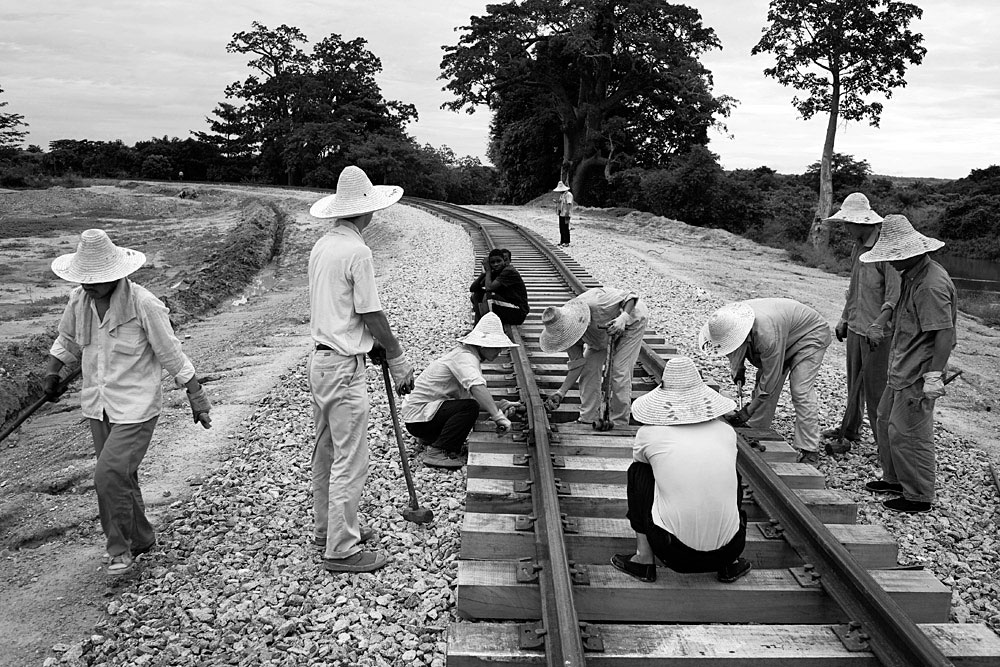 Chinese railways workers adjust tracks outside, Dondo, Angola, 2007.  Hundreds of workers live in rural camps along the tracks and all the equipment are imported from China. The Chinese are upgrading two railway lines in Angola. 