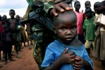 A soldier from the Ugandan National Army interact with refugee children in Pagak, camp for displayed people in northern Uganda, 2005. About 1.5 million people have fled villages and live in about 180 squalid Internally Displaced People (IDP) camps, which has changed rural life in Northern Uganda. 