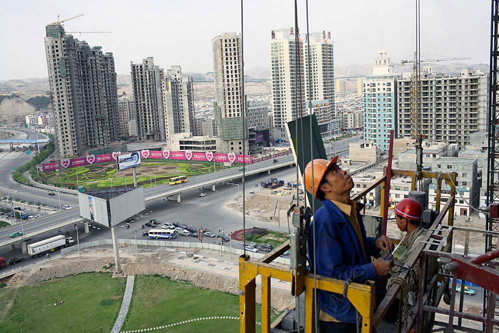 Migrant workers construct a new exclusive residential building in central Lanzhou, China, 2007