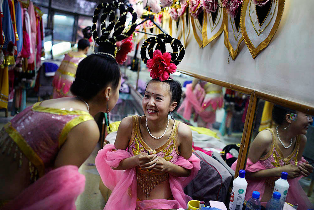 Performers in the Fetian Song and Dance Troupe dress backstage before an evening show in a hotel, DunHuang, China, 2007
