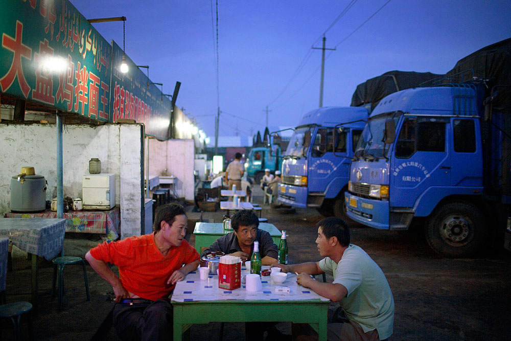 Truck drivers share a meal at a truck stop outside Turpan, China, 2007