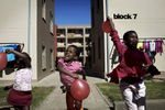 Children play outside the apartment block where they live on May 4, 2013 in Jabulani, section of Soweto, South Africa. Jabulani flats is one of the first apartment building developments in Soweto and local residents are just beginning learn how to live in an apartment. The residents of Soweto has seen massive investment such as shopping malls, parks, outdoor gyms in the township. (Photo by: Per-Anders Pettersson)