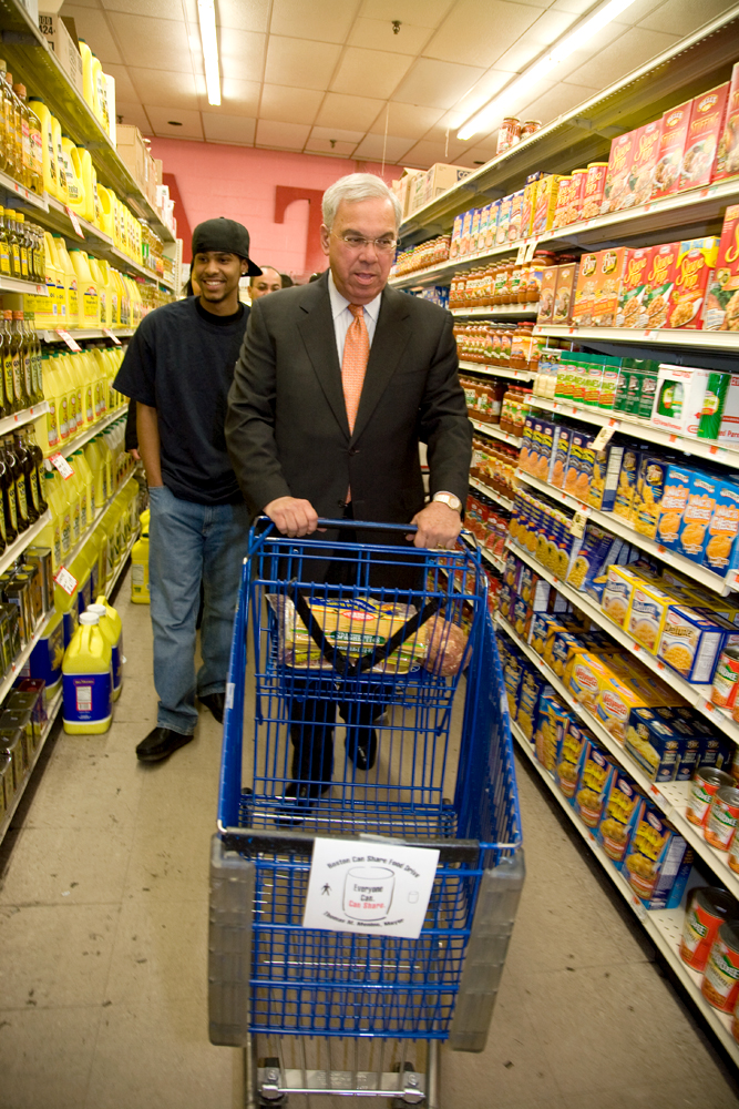 A Hyde Square Task Force youth leader and Boston Mayor Thomas Menino grocery shopping with a budget of $21, the average weekly amount allotted to food stamp recipients.