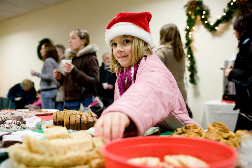 A young girl reaches for a Rice Krispie treat during holiday festivities at the Living Hope Church.