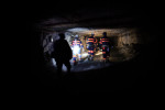 Coal miners illuminate their way with head lamps as they walk the long passage ways of the Cumberland mine in Waynesburg, Pa.