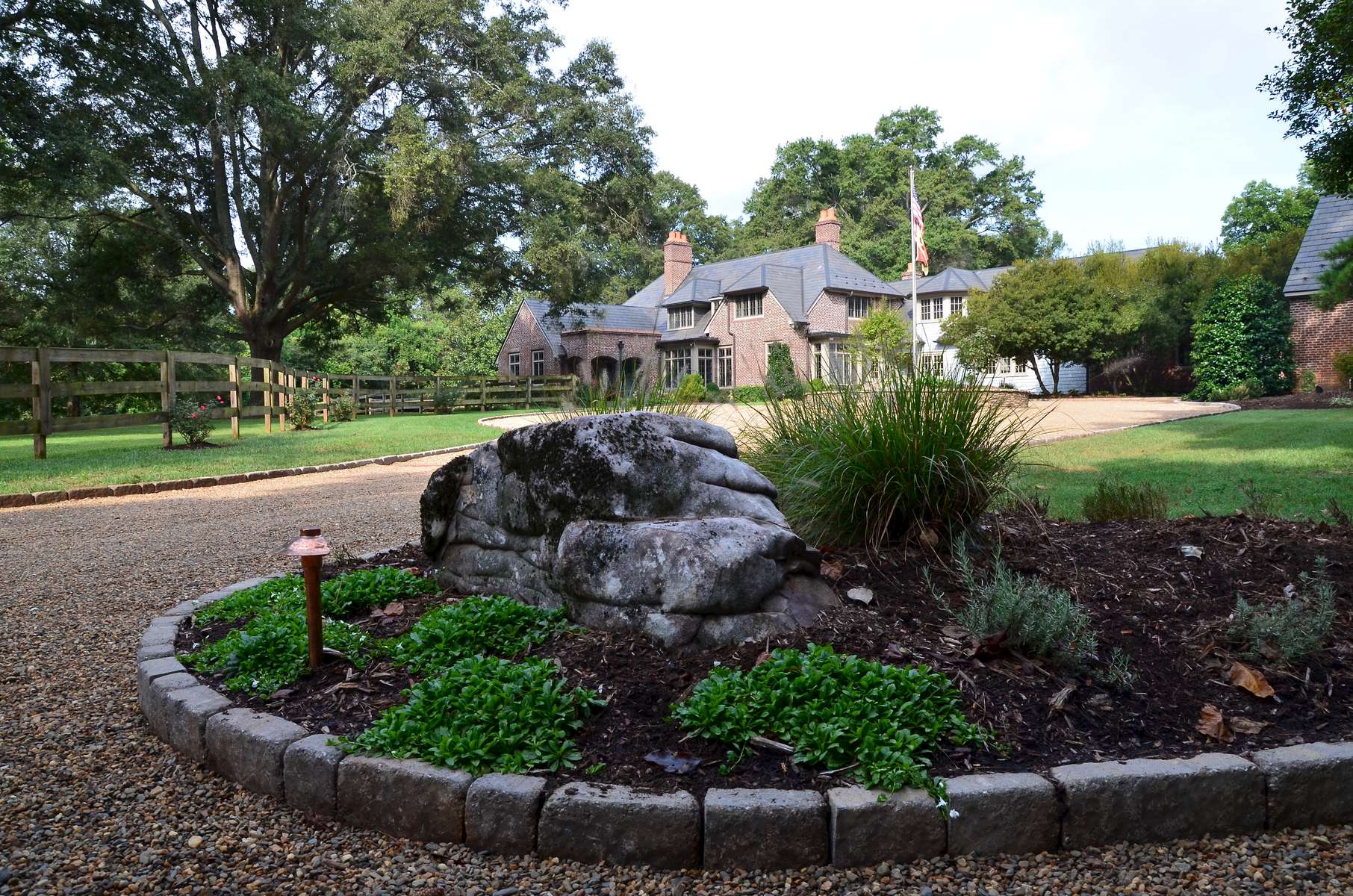 The stone planting bed serves as the first focal point upon entry and delights the senses featuring Mazus, a flowering ground cover, as well as other carefully selected perennials. 
