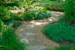 A meandering crushed stone path leads through the entrance garden to the backyard.