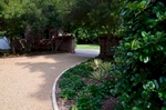 The secondary entrance is flanked by a classic brick columned wall that expands the perimeter. Using the existing wax myrtles trees we also encompassed new complimentary plants such as Yuccas and Ajuga to add depth and dimension. The addition of outdoor lighting also brings ambiance to the space.