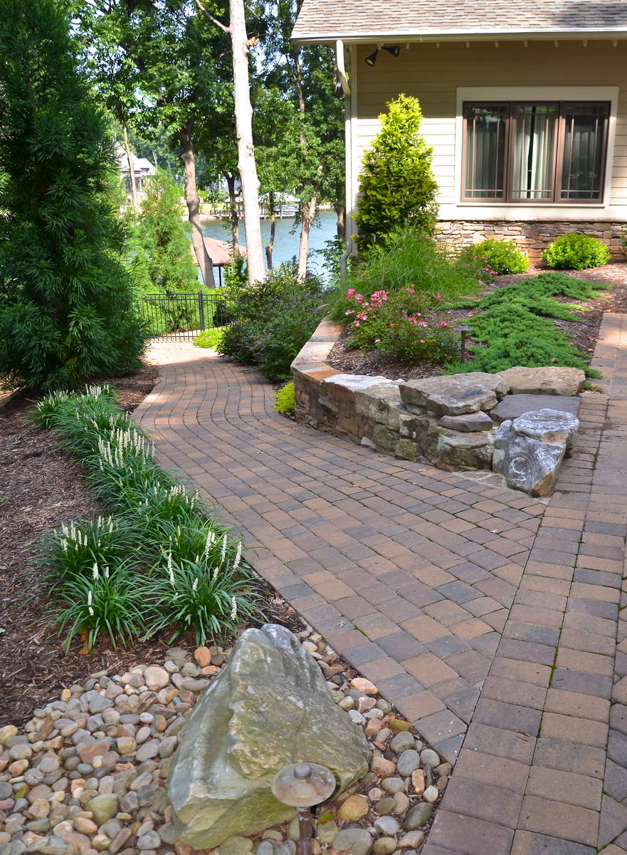 Emerging from the drive, a cobble path winds down around and through the backyard gardens. Designed without steps, it becomes the path of choice for lawnmower or wheelbarrow, as well as a cool, direct foot route to the dock on warm summer days. 